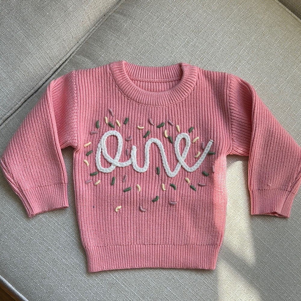 Pink Knit Sweater with “One” Embroidery